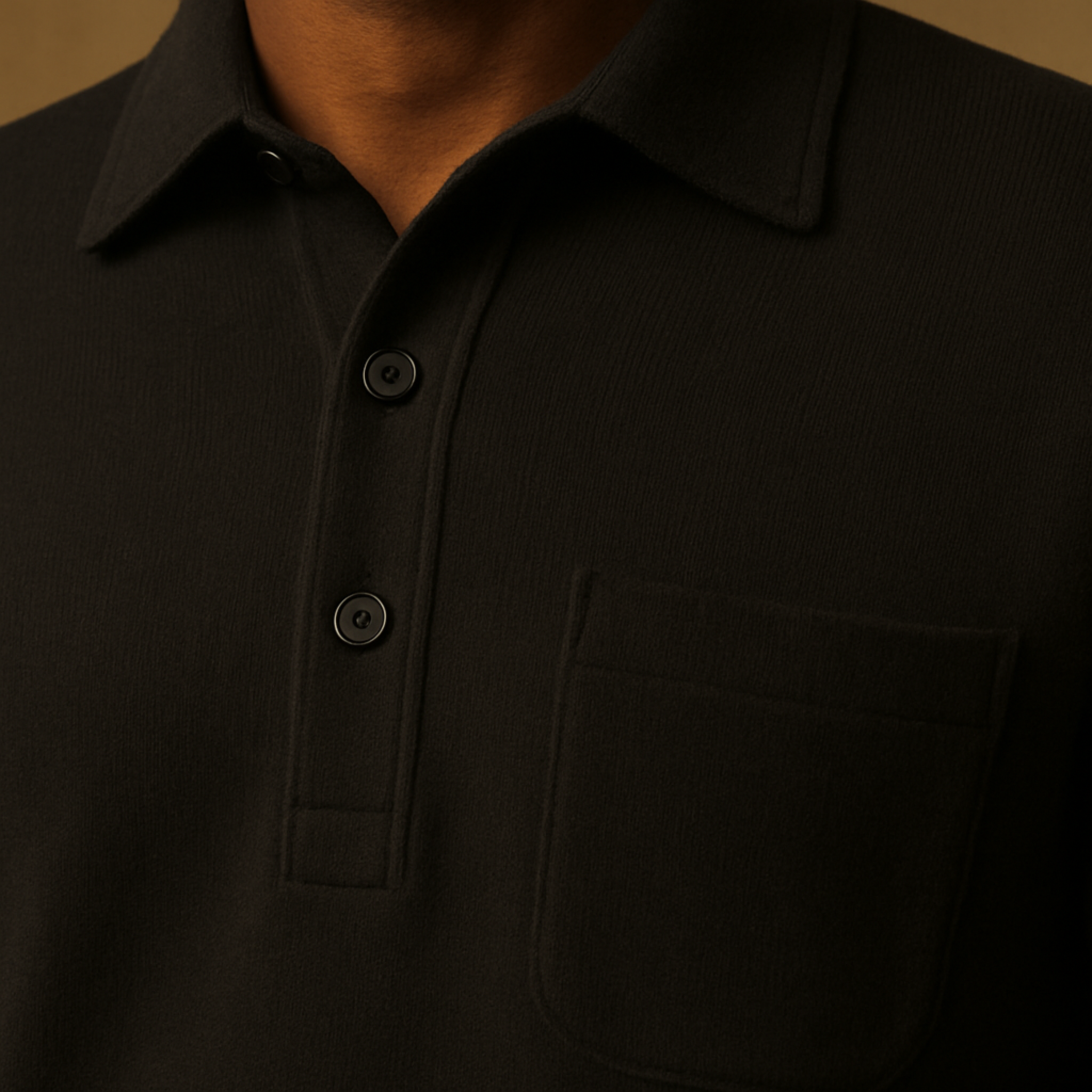 Close-up of a black polo shirt with buttons on a brown background